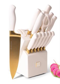 a white and gold knife holder with several knives in it next to some radishes