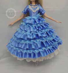 the doll is wearing a blue dress with ruffles on it's skirt