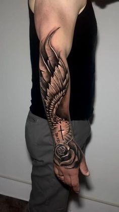 a man with a cross and wings tattoo on his arm