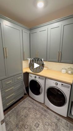 a washer and dryer in a small room with gray cupboards on the walls