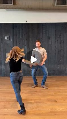 two people are dancing in an empty room