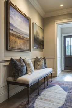 a white bench sitting in front of a doorway next to a painting on the wall