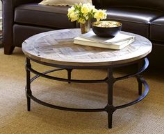 a living room with a couch, coffee table and flower arrangement on the center table