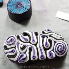 an odd looking object sitting on top of a table next to another object that is purple and white