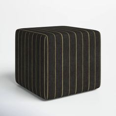 a black and brown striped ottoman sitting on top of a white floor