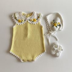 a baby's outfit, hat and booties are laid out on a table