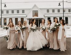 a group of women standing next to each other in front of a white building with snow on the ground