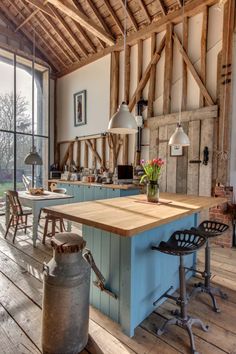 a kitchen with an island in the middle and lots of chairs on the other side