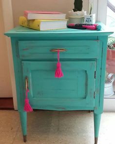 an old dresser painted turquoise with pink tassels