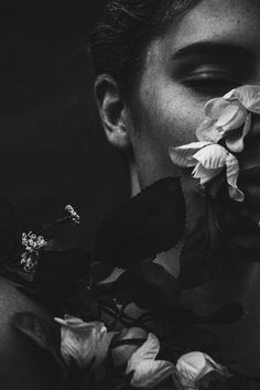 black and white photograph of a man with flowers in his mouth