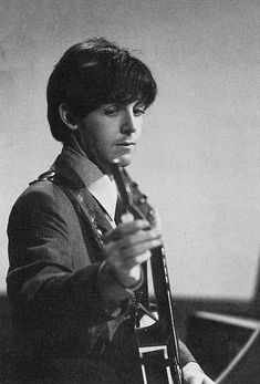 an old photo of a young man holding a guitar