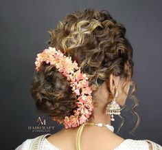 the back of a woman's head with flowers in her hair