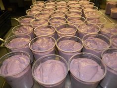 several buckets filled with purple pudding sitting on top of a metal counter next to each other