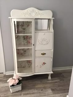 a white cabinet with flowers on it in a room