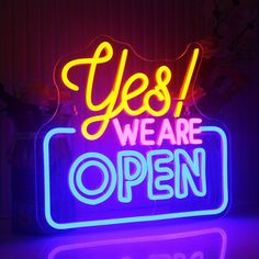 a neon sign that says yes we are open