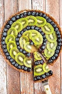 sliced kiwis and blueberries on top of a pie