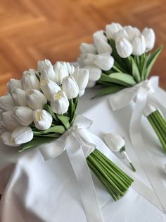 two bouquets of white tulips tied together