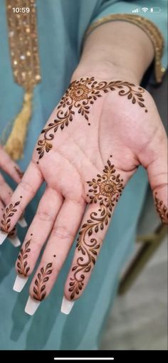 a woman's hand with henna tattoos on it