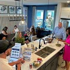 a group of people standing around a kitchen counter