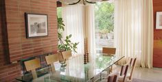 a dining room table with chairs and a brick wall