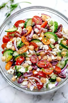 a salad with cucumbers, tomatoes, chickpeas and feta cheese