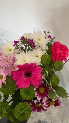 a vase filled with lots of different colored flowers