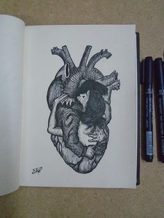 an open book with a drawing of two people hugging in the shape of a heart