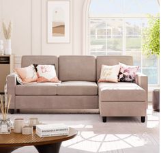 a living room filled with furniture and a coffee table in front of a large window