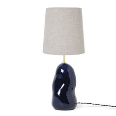 a blue ceramic lamp with a beige linen shade