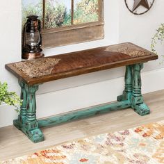 a wooden bench sitting on top of a hard wood floor next to a painting and potted plant