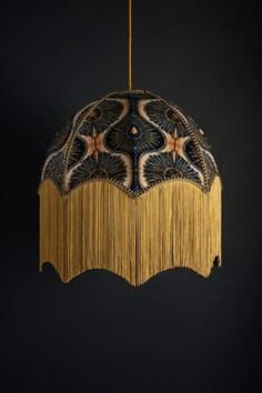 a light hanging from a ceiling with fringes on the sides and stars in the middle