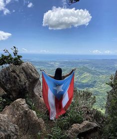 a woman holding a texas flag on top of a mountain