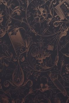 the wall paper has an intricate design and is dark brown with gold foil on it