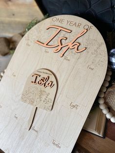 a wooden plaque with the words, one year of tsk on it and an open book