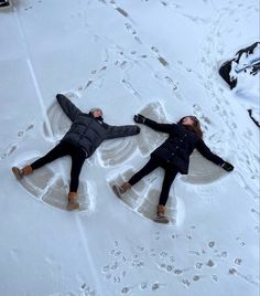 two people are laying in the snow with their arms around each other and one person is lying down