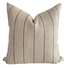 a beige and black striped pillow on a white background