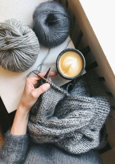 someone is knitting yarn with scissors and a cup of coffee