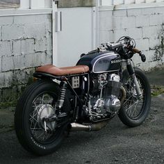 a black and brown motorcycle parked in front of a building