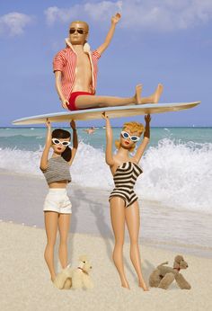 two women in swimsuits holding up a surfboard above their heads on the beach