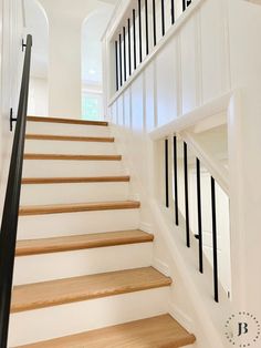 there is a set of stairs leading up to the second floor in this house with white walls and black railings