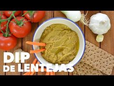 dip de lentellas in a bowl with vegetables and crackers on the side