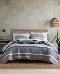 a bed sitting in a bedroom on top of a rug next to a table with a potted plant