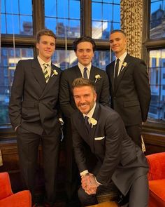 four men in suits posing for the camera