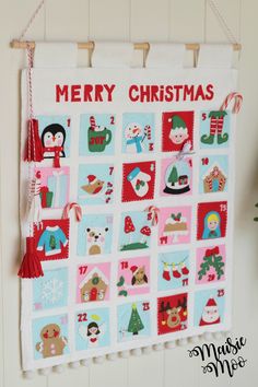 a merry christmas quilt hanging on a wall with decorations and ornaments around the edges,