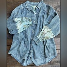 Denim Feel With Floral Fabric Inserts, Is A Beautiful Cottagecore Button Up. The Stripes Are Reminiscent Of Ticking In Grandma's Feather Bed! Fading Details And Distressing Throughout, Create A Lived In Look. One Size Bust 26" Length 28" By Jaded Gypsy Blue Button-up Denim Top With Button Cuffs, Blue Denim Button-up Top With Button Cuffs, Spring Washed Blue Tops With Button Cuffs, Spring Washed Button-up Blouse, Spring Denim Tops With Button Cuffs, Spring Indigo Button-up Tops, Spring Chambray Shirt With Buttons, Spring Chambray Button-up Blouse, Indigo Button-up Top For Spring