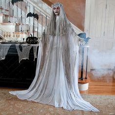 a woman dressed up as a ghost standing in front of some stairs