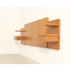 a wooden shelf mounted to the side of a wall with two shelves on each end