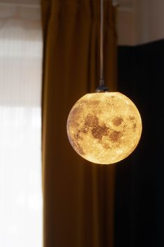 a full moon hanging from a ceiling light