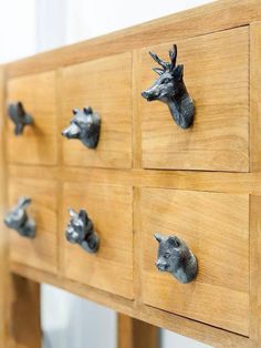 the drawers are made out of wood and have metal deer head knobs on them