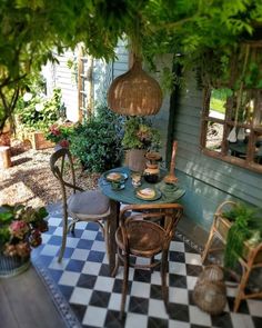 an outdoor dining area with chairs, table and potted plants